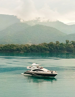 Lancha na agua com montanhas de fundo.